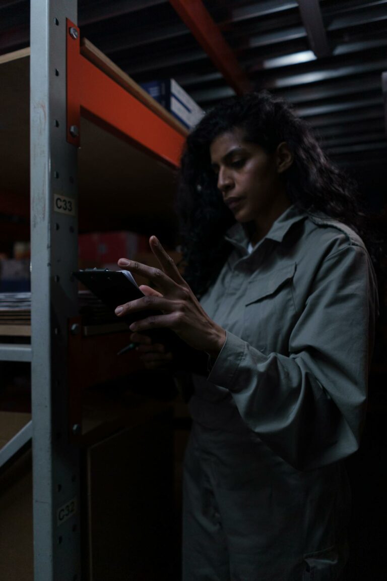 A dedicated female warehouse worker reviews inventory on a tablet.