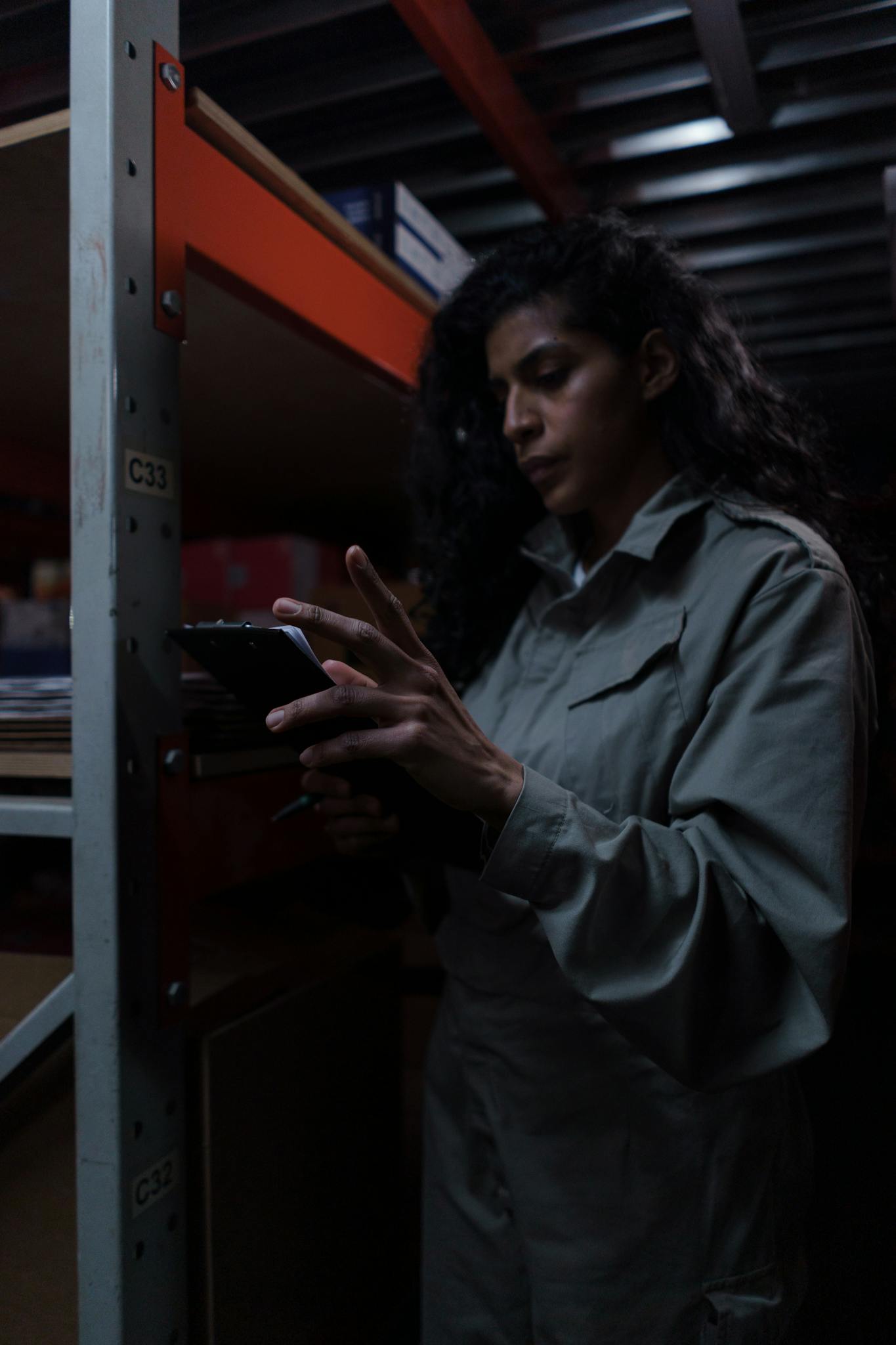 A dedicated female warehouse worker reviews inventory on a tablet.